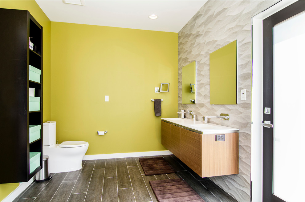 Diseño de cuarto de baño actual con lavabo integrado, armarios abiertos, puertas de armario de madera en tonos medios, sanitario de dos piezas y paredes verdes