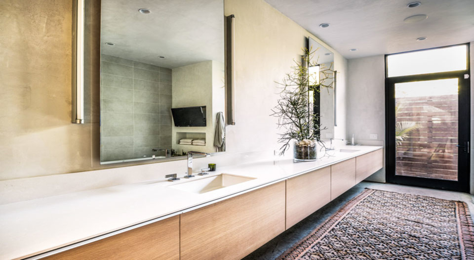 Aménagement d'une grande salle de bain principale moderne en bois clair avec un placard à porte plane, un mur beige, sol en béton ciré, un lavabo encastré et un sol gris.