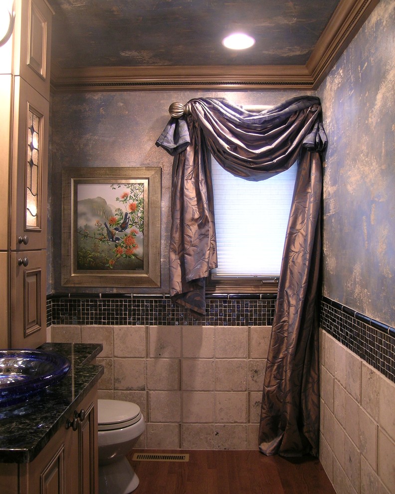 Example of a mid-sized tuscan beige tile and ceramic tile dark wood floor bathroom design in Other with medium tone wood cabinets, louvered cabinets, a one-piece toilet, blue walls and granite countertops