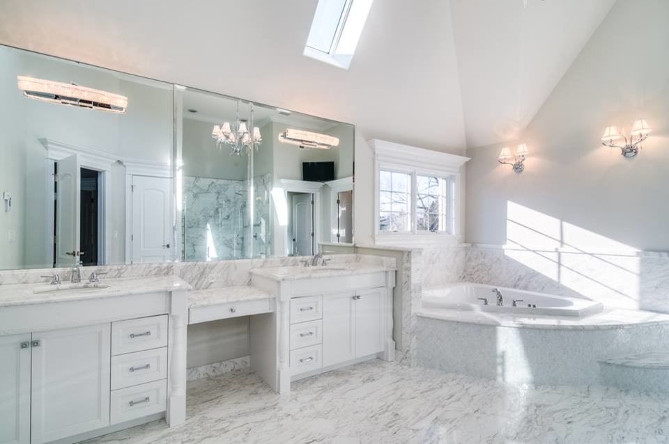 Ispirazione per una grande stanza da bagno padronale classica con ante con riquadro incassato, ante bianche, vasca da incasso, piastrelle grigie, piastrelle di marmo, pareti grigie, pavimento in marmo, lavabo sottopiano, top in marmo e pavimento bianco