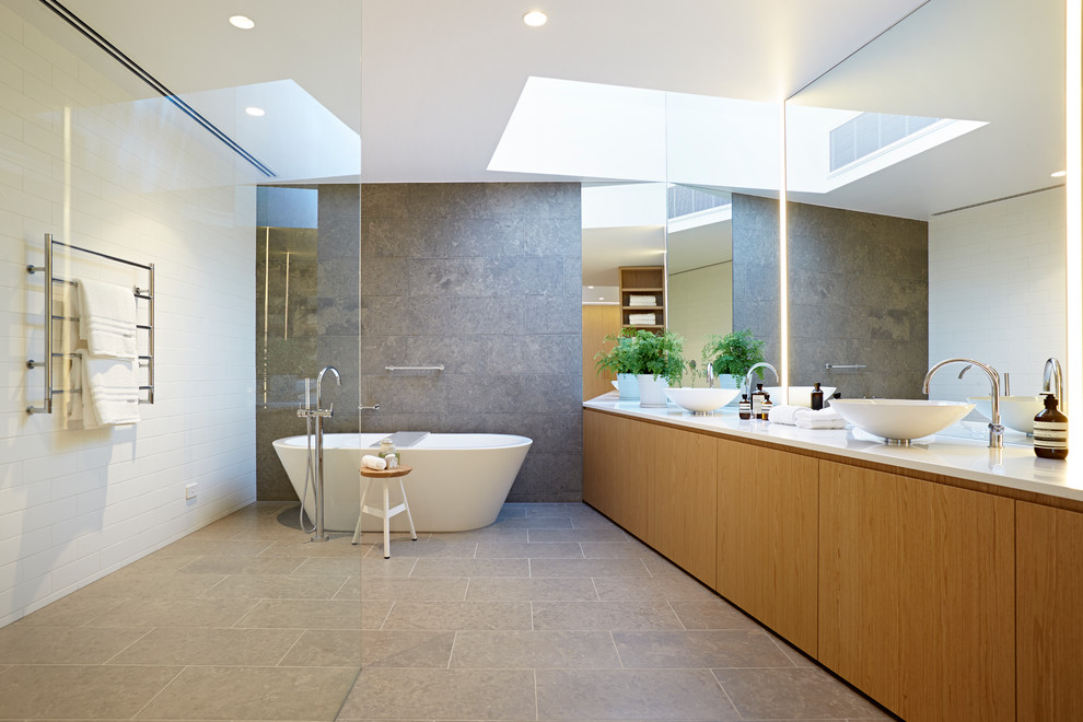 Modernes Badezimmer mit hellen Holzschränken und Kalkstein in Melbourne