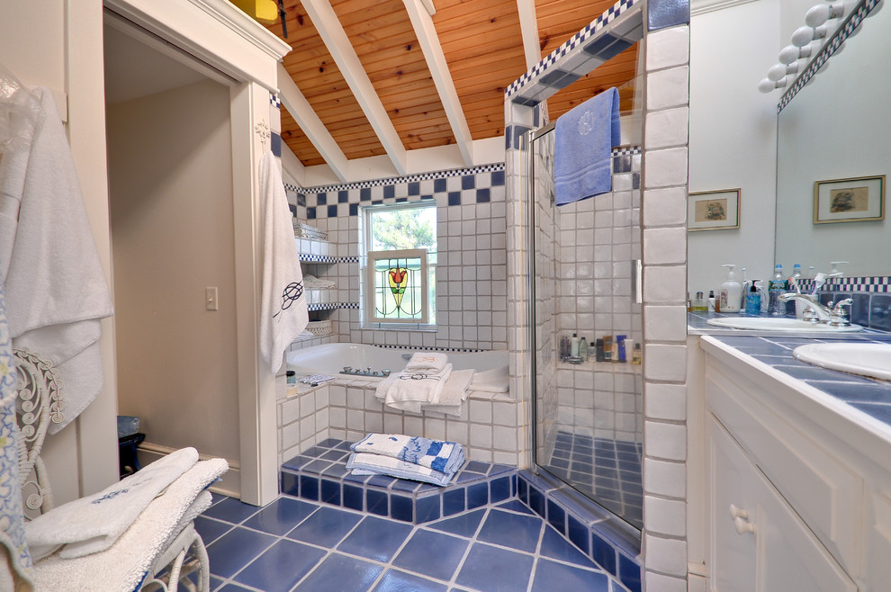 На фото: большая главная ванная комната в морском стиле с накладной раковиной, фасадами с утопленной филенкой, белыми фасадами, столешницей из плитки, накладной ванной, душем в нише, раздельным унитазом, синей плиткой, терракотовой плиткой, белыми стенами и полом из терракотовой плитки с