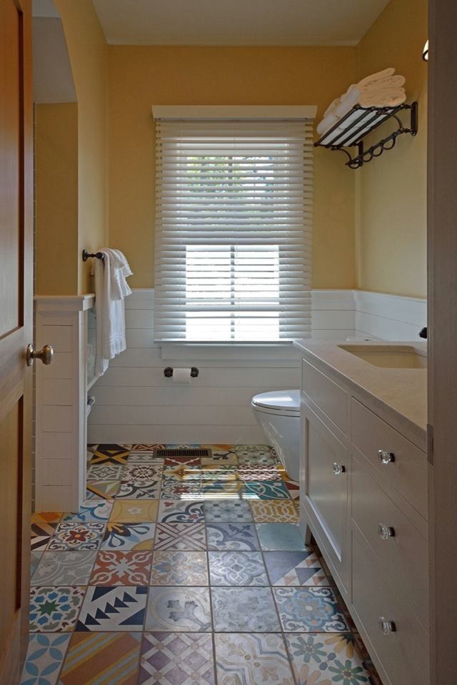 Inspiration for a contemporary family bathroom in Portland Maine with a shower/bath combination, a one-piece toilet, yellow walls, mosaic tile flooring, multi-coloured floors and a shower curtain.
