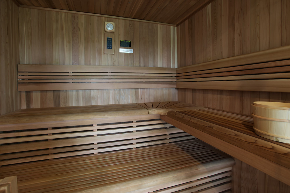 Diseño de sauna marinera de tamaño medio con ducha empotrada, paredes grises, suelo vinílico, suelo marrón y ducha con puerta con bisagras