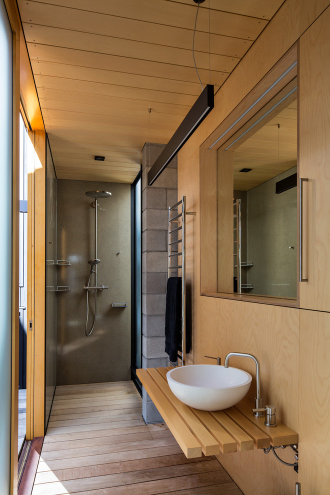 Idée de décoration pour une salle de bain design en bois clair avec un placard avec porte à panneau encastré, un plan de toilette en bois et une douche ouverte.