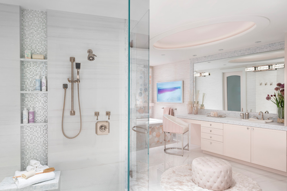 На фото: главная ванная комната в стиле неоклассика (современная классика) с плоскими фасадами, полновстраиваемой ванной, душем в нише, серой плиткой, розовой плиткой, белой плиткой, розовыми стенами, накладной раковиной, серым полом, душем с распашными дверями, серой столешницей, встроенной тумбой, многоуровневым потолком и обоями на стенах с
