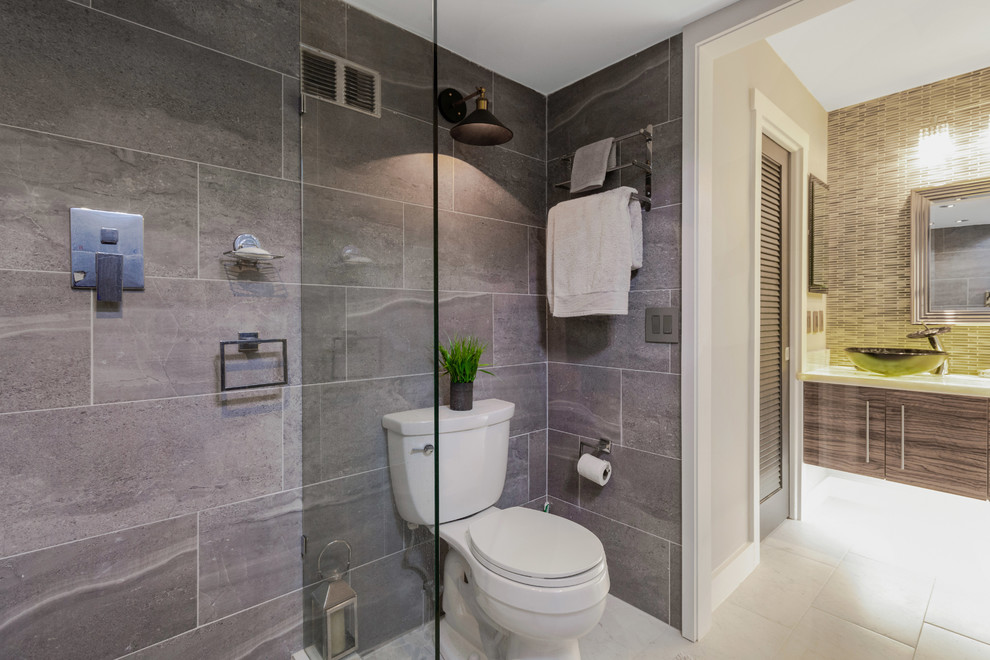 Design ideas for a medium sized contemporary ensuite bathroom in Miami with freestanding cabinets, brown cabinets, a double shower, a two-piece toilet, grey tiles, slate tiles, brown walls, ceramic flooring, a vessel sink, onyx worktops, white floors, an open shower and multi-coloured worktops.