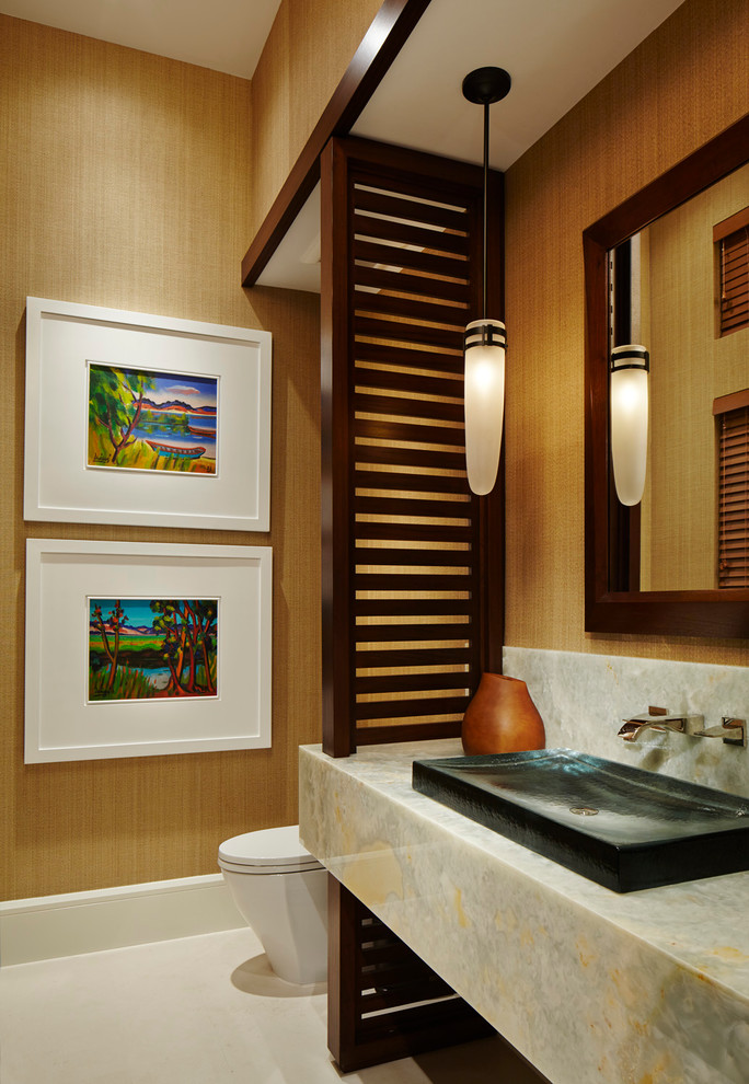 Стильный дизайн: ванная комната среднего размера в современном стиле с настольной раковиной, столешницей из оникса, унитазом-моноблоком, желтыми стенами, полом из известняка и душевой кабиной - последний тренд