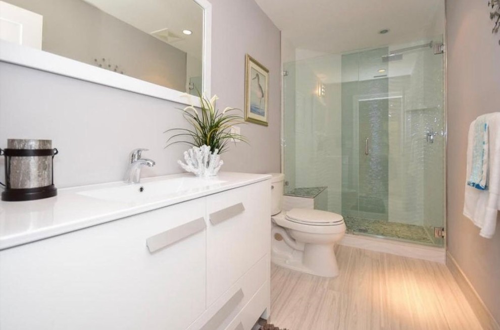 Idéer för att renovera ett mellanstort funkis badrum med dusch, med släta luckor, vita skåp, ett hörnbadkar, en öppen dusch, en toalettstol med hel cisternkåpa, vit kakel, stenhäll, grå väggar, ljust trägolv, ett nedsänkt handfat och bänkskiva i täljsten