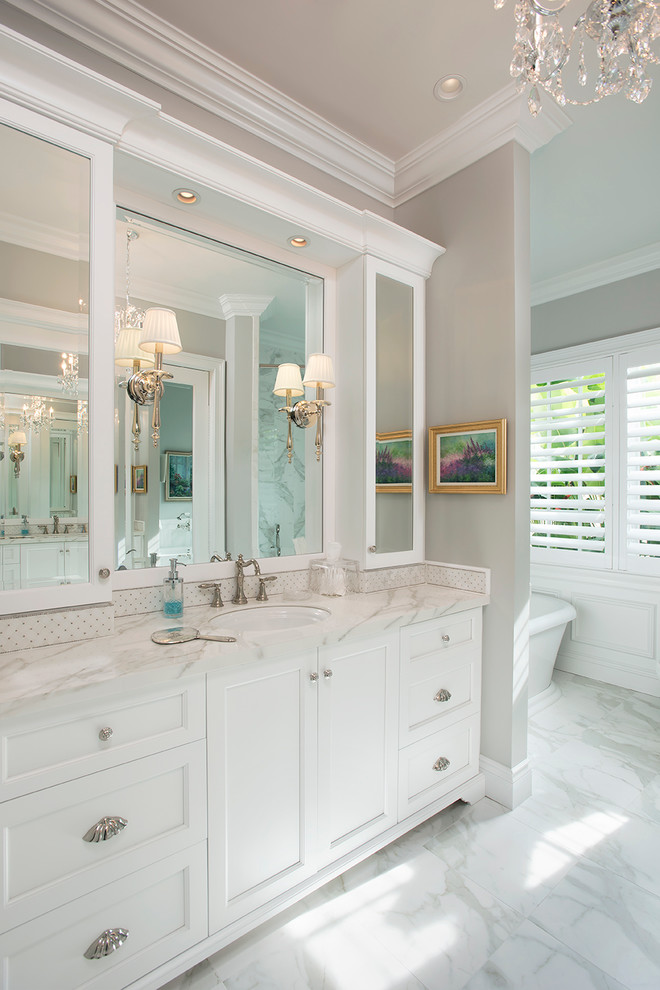 Idéer för mellanstora vintage en-suite badrum, med möbel-liknande, vita skåp, ett fristående badkar, vit kakel, beige väggar, marmorgolv, ett undermonterad handfat och marmorbänkskiva