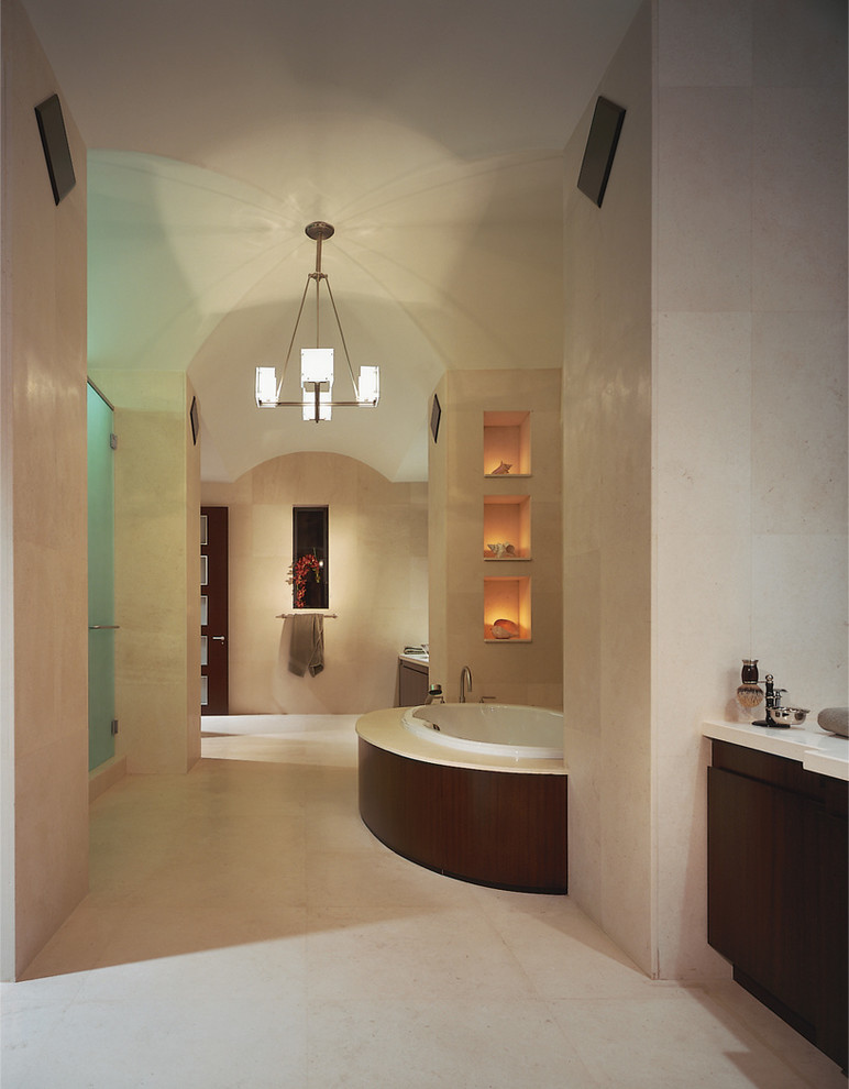 Идея дизайна: огромная главная ванная комната в классическом стиле с плоскими фасадами, фасадами цвета дерева среднего тона, накладной ванной, душем в нише, бежевой плиткой, плиткой из известняка, бежевыми стенами, полом из известняка, столешницей из известняка, бежевым полом и душем с распашными дверями