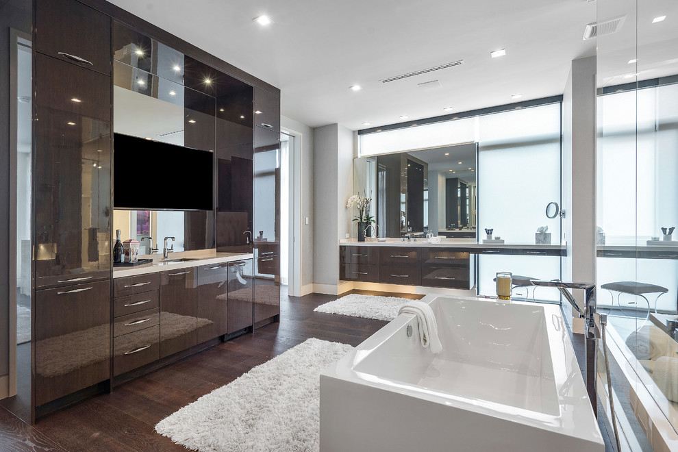 Large minimalist master medium tone wood floor and brown floor bathroom photo in Miami with flat-panel cabinets, dark wood cabinets, a wall-mount toilet, beige walls, an integrated sink, onyx countertops, a hinged shower door and white countertops