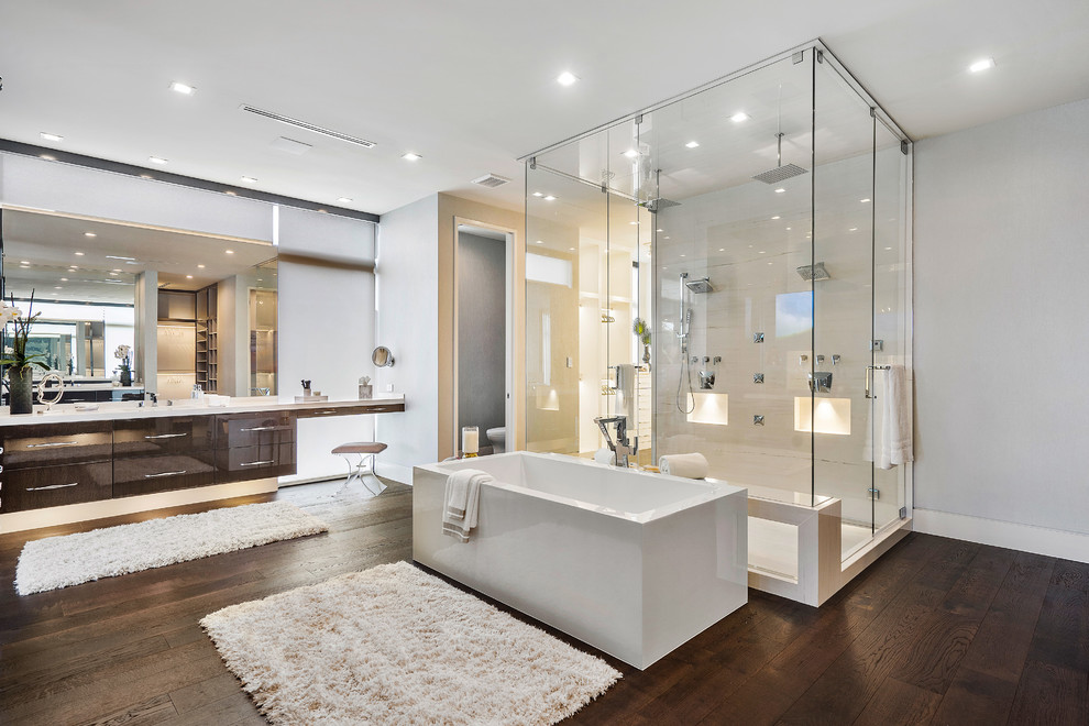 Design ideas for a large contemporary ensuite bathroom in Miami with flat-panel cabinets, dark wood cabinets, a freestanding bath, a double shower, onyx worktops, brown floors, a hinged door, white worktops, white tiles, grey walls and dark hardwood flooring.