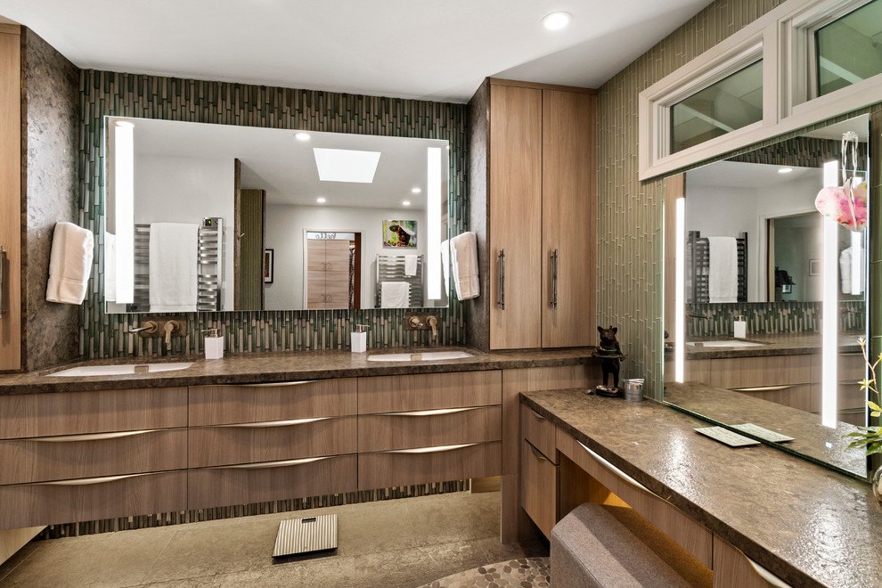 Cette image montre une salle de bain principale design en bois brun avec un placard à porte plane, un carrelage vert, un carrelage en pâte de verre, un plan de toilette en calcaire, un plan de toilette marron, un lavabo encastré et un sol gris.