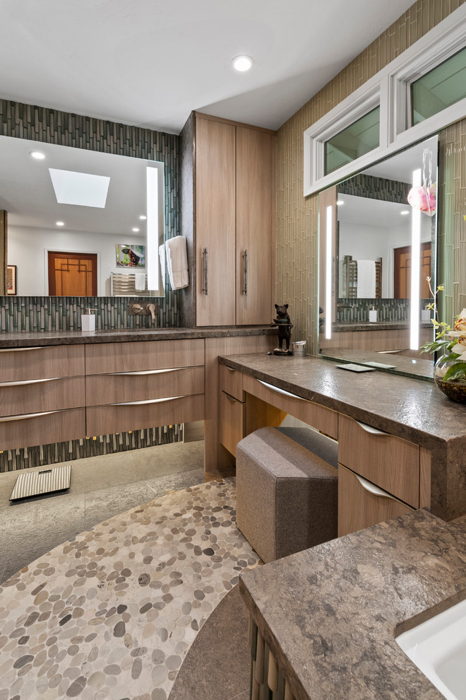 На фото: главная ванная комната в стиле модернизм с плоскими фасадами, светлыми деревянными фасадами, зеленой плиткой, стеклянной плиткой, столешницей из известняка и коричневой столешницей