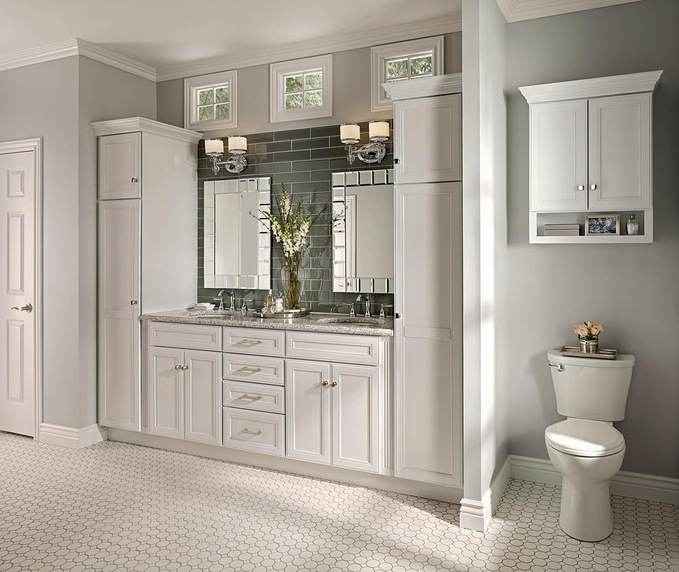 Стильный дизайн: главная ванная комната в классическом стиле с фасадами с утопленной филенкой, белыми фасадами, столешницей из гранита, серой плиткой, стеклянной плиткой и серыми стенами - последний тренд