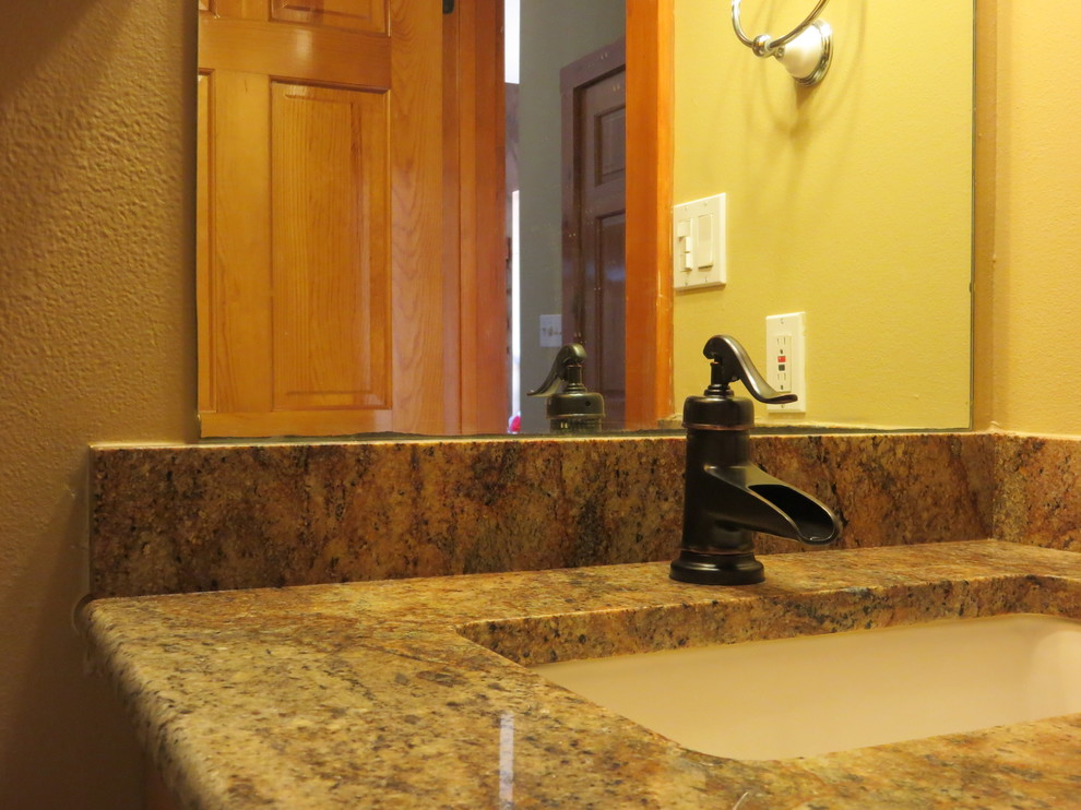 Kleines Klassisches Duschbad mit Unterbauwaschbecken, profilierten Schrankfronten, hellbraunen Holzschränken, Granit-Waschbecken/Waschtisch, Duschnische und Wandtoilette mit Spülkasten in Austin
