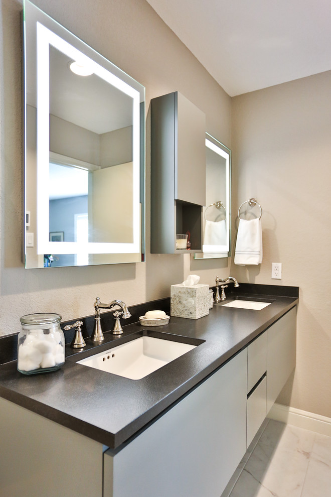 Mid-sized trendy master gray tile and porcelain tile porcelain tile bathroom photo in Austin with flat-panel cabinets, gray cabinets, a one-piece toilet, gray walls, an undermount sink and granite countertops