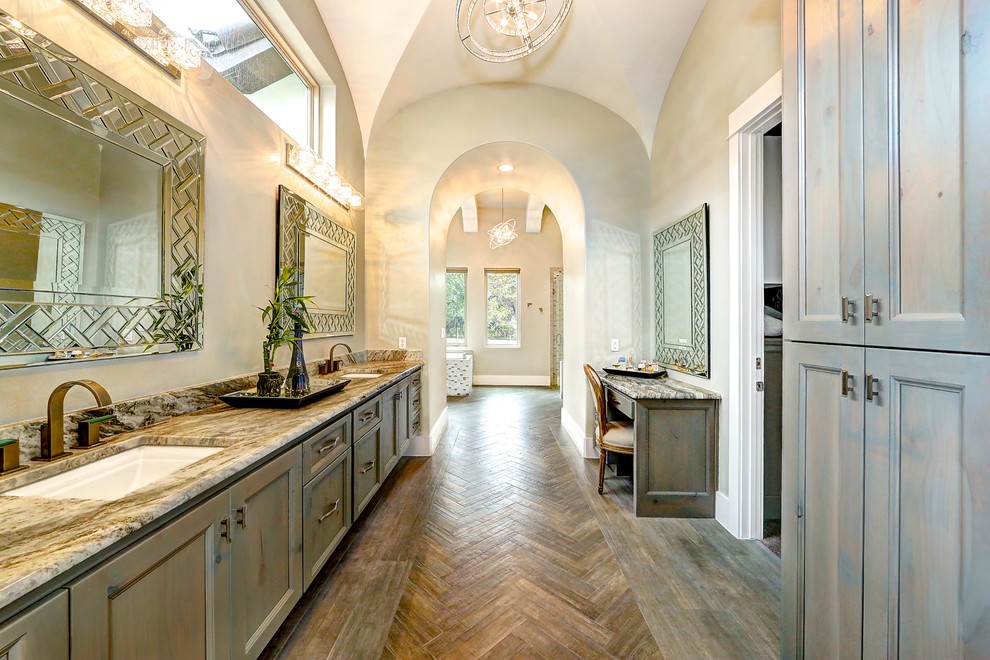Expansive traditional ensuite bathroom in Austin with recessed-panel cabinets, distressed cabinets, a built-in bath, a corner shower, multi-coloured tiles, mosaic tiles, grey walls, granite worktops, brown floors, a hinged door, dark hardwood flooring and a submerged sink.