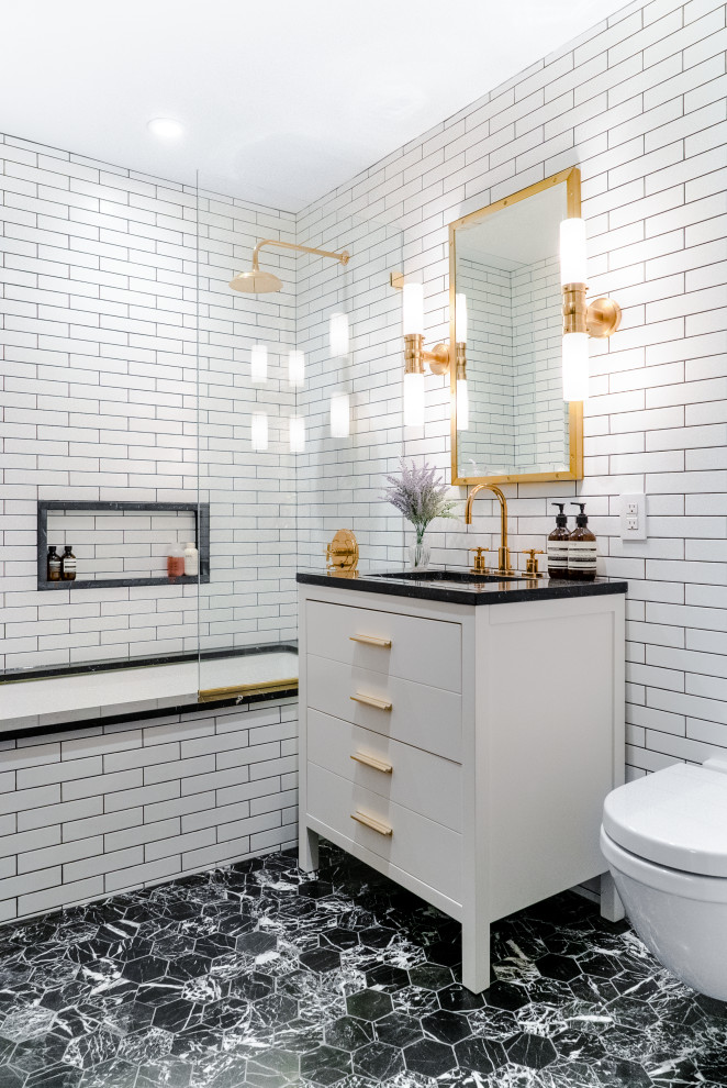Bild på ett litet funkis svart svart badrum, med släta luckor, vita skåp, ett undermonterat badkar, en dusch/badkar-kombination, vit kakel, tunnelbanekakel, ett undermonterad handfat, svart golv, med dusch som är öppen, en vägghängd toalettstol, vita väggar, marmorgolv och marmorbänkskiva