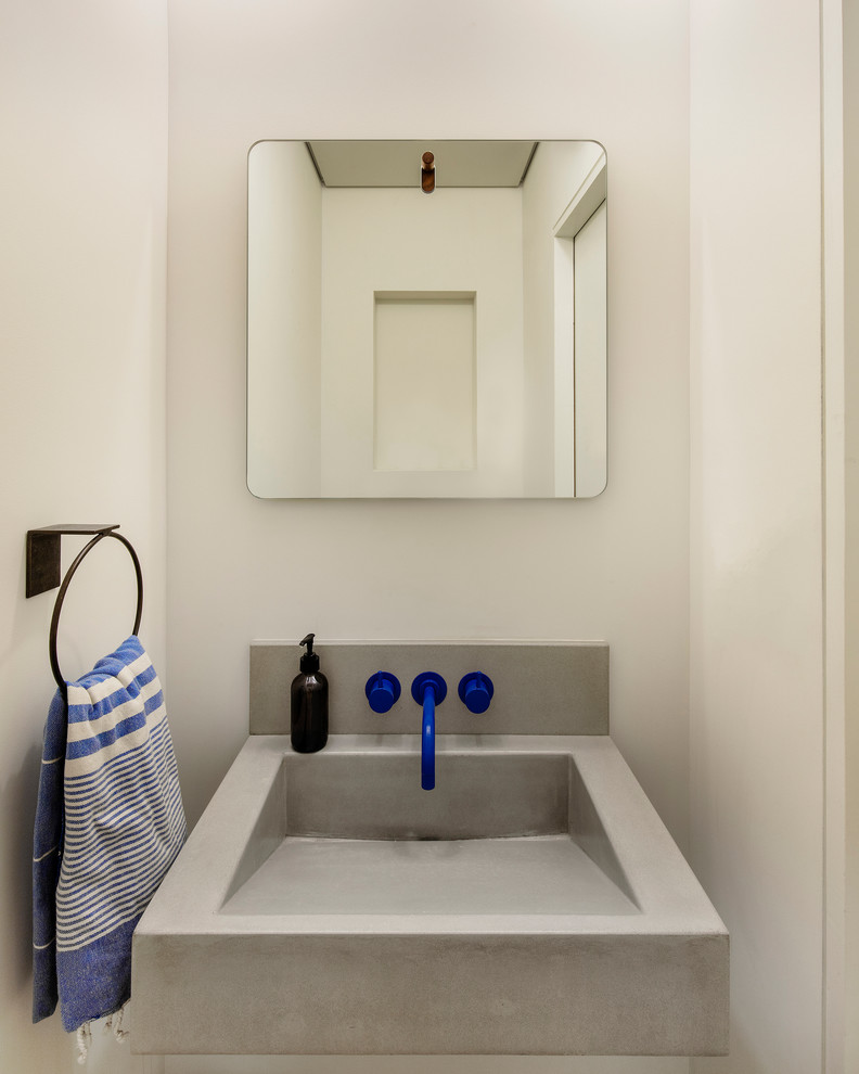 Small modern bathroom in New York with a wall-mounted sink and concrete worktops.