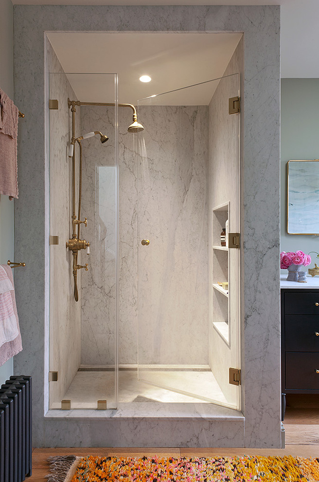 Imagen de cuarto de baño tradicional renovado con puertas de armario azules, ducha empotrada, suelo de madera en tonos medios, encimera de mármol y ducha con puerta con bisagras