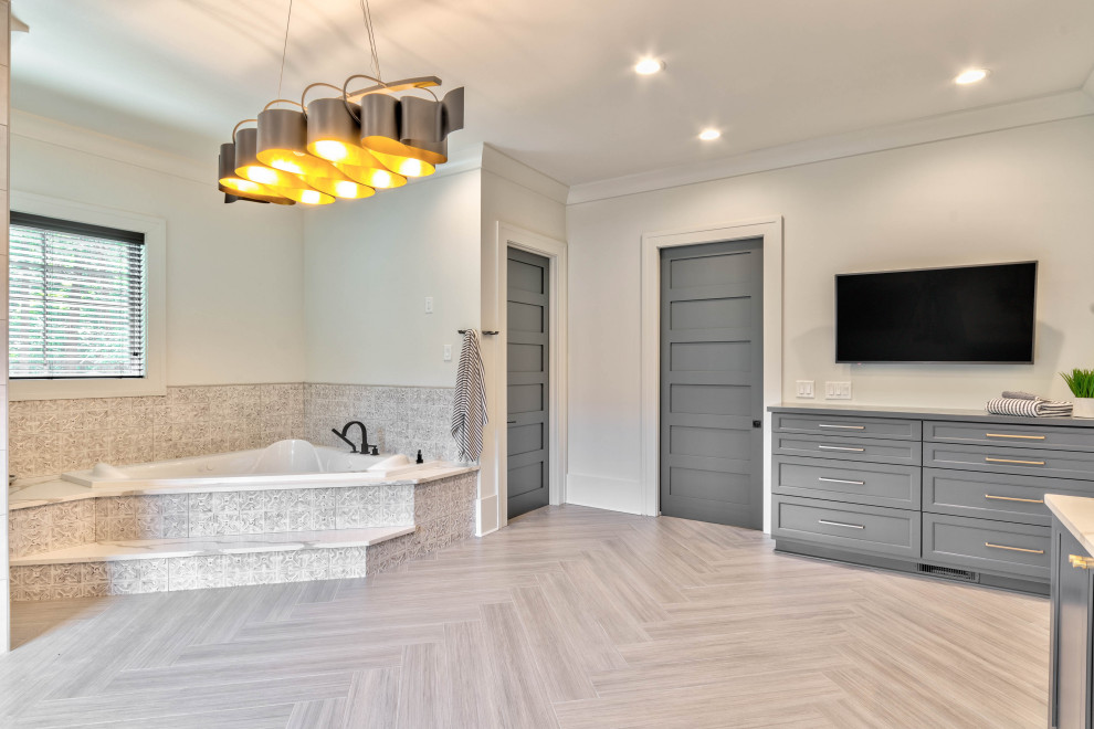 Design ideas for an expansive modern ensuite bathroom in Atlanta with shaker cabinets, grey cabinets, a built-in bath, a double shower, beige tiles, porcelain tiles, white walls, porcelain flooring, a submerged sink, engineered stone worktops, grey floors, a hinged door, white worktops, a shower bench, double sinks and a built in vanity unit.