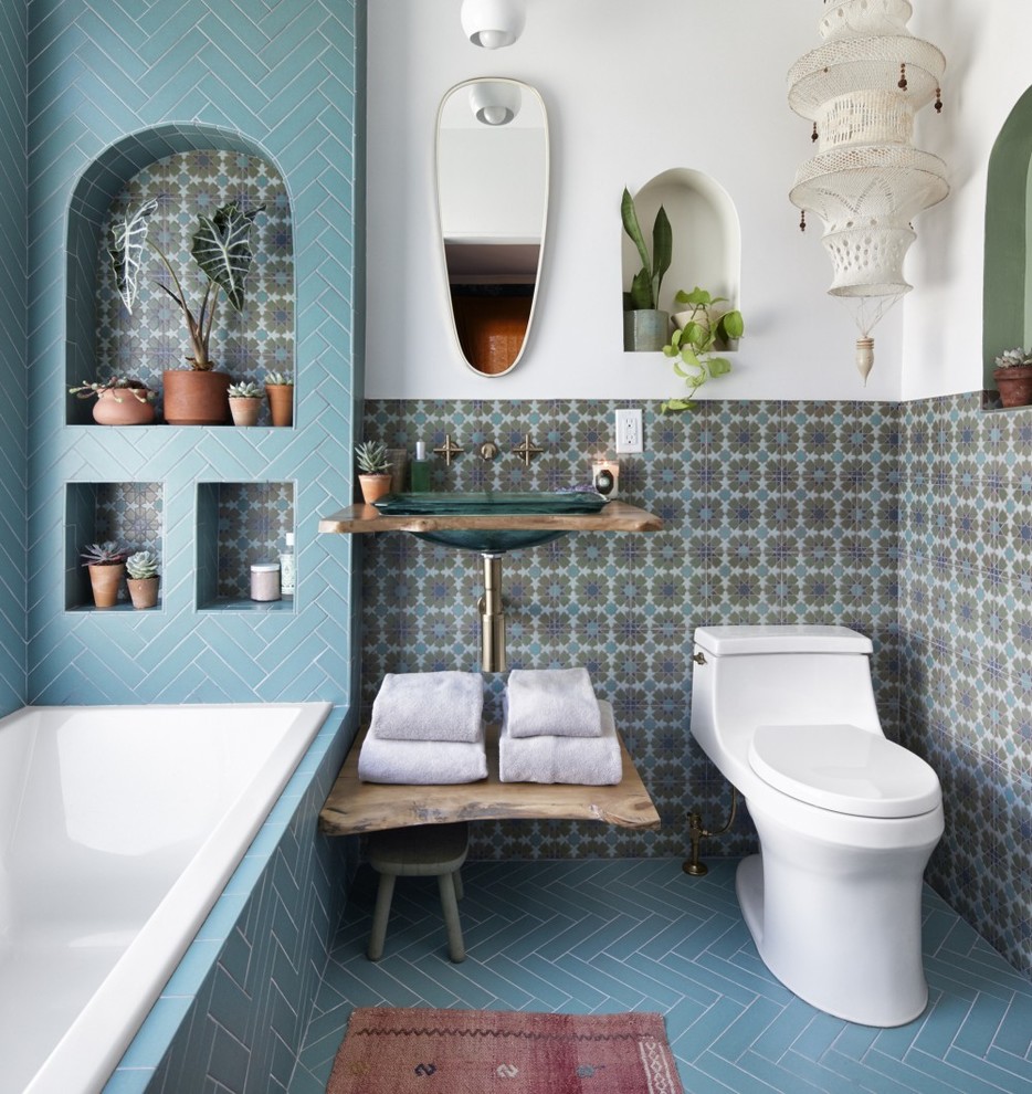 Bild på ett medelhavsstil brun brunt badrum, med ett platsbyggt badkar, flerfärgad kakel, vita väggar, ett nedsänkt handfat, träbänkskiva och blått golv