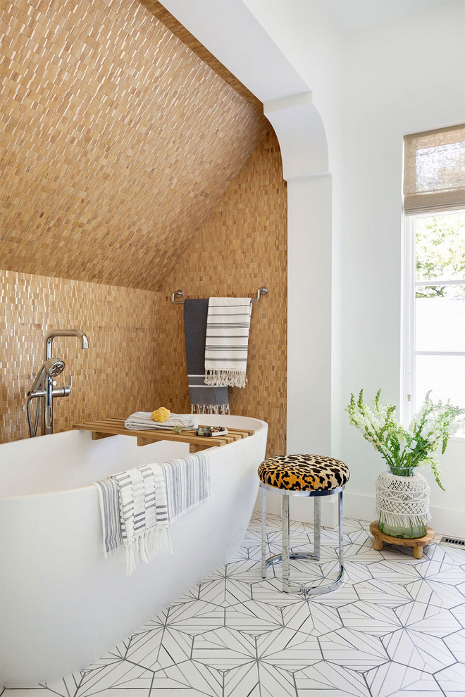 На фото: главная ванная комната в стиле фьюжн с отдельно стоящей ванной, бежевой плиткой, белыми стенами и разноцветным полом с