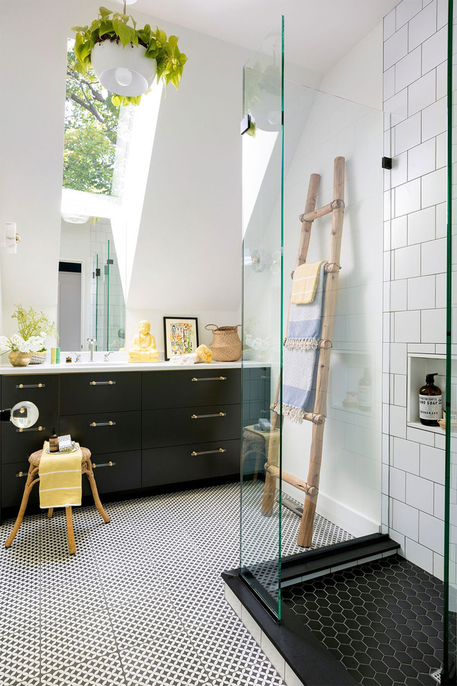 Stilmix Duschbad mit flächenbündigen Schrankfronten, schwarzen Schränken, weißen Fliesen, weißer Wandfarbe, buntem Boden und weißer Waschtischplatte in Minneapolis