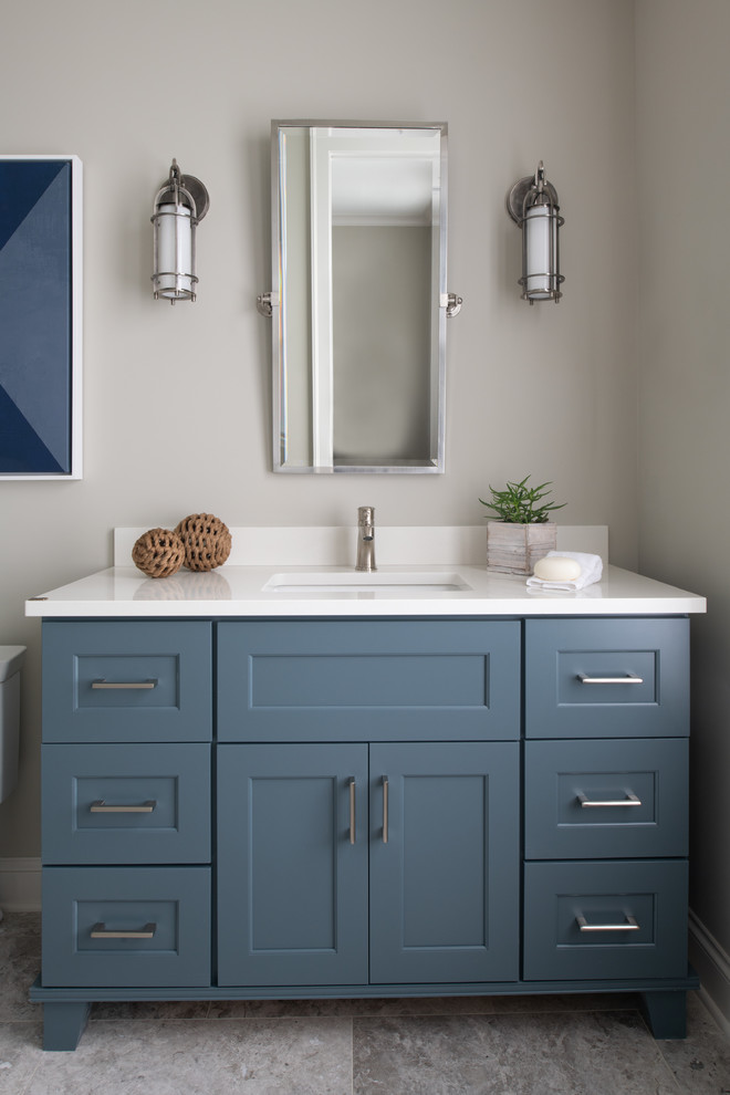 Foto de cuarto de baño marinero con armarios estilo shaker, puertas de armario azules, paredes grises, lavabo bajoencimera, suelo gris, encimeras blancas y espejo con luz