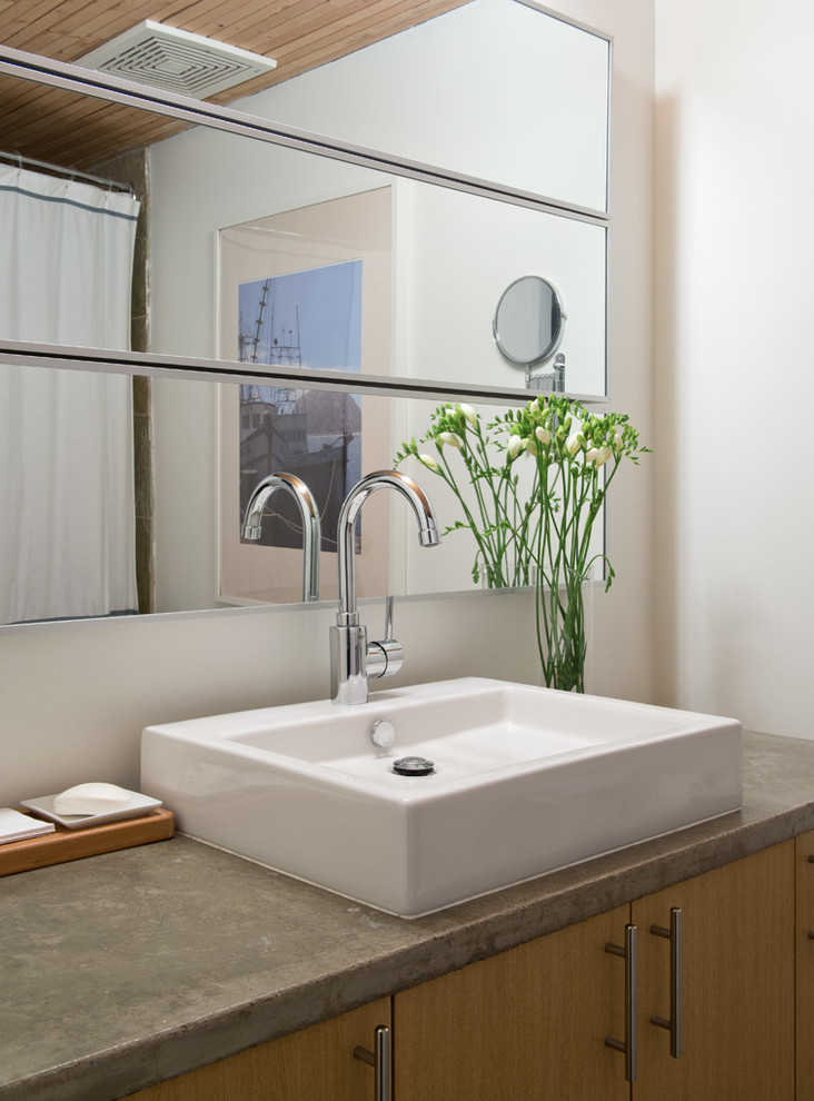 トロントにあるインダストリアルスタイルのおしゃれな浴室 (ベッセル式洗面器、フラットパネル扉のキャビネット、中間色木目調キャビネット、コンクリートの洗面台) の写真