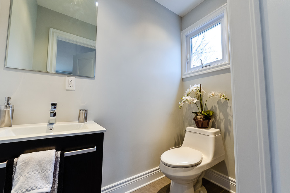 This is an example of a small contemporary ensuite bathroom in Montreal with an integrated sink, flat-panel cabinets, black cabinets, engineered stone worktops, a claw-foot bath, a corner shower, a one-piece toilet, grey tiles, porcelain tiles, white walls and porcelain flooring.