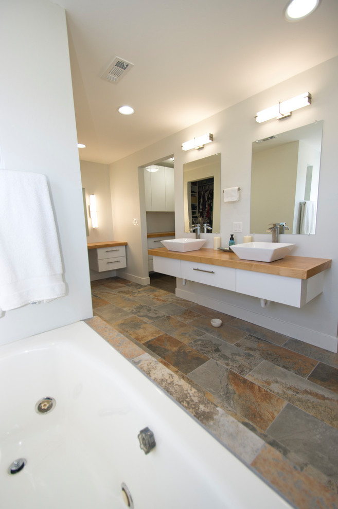 На фото: большая главная ванная комната в скандинавском стиле с открытыми фасадами, накладной ванной, унитазом-моноблоком, полом из керамогранита и столешницей из дерева