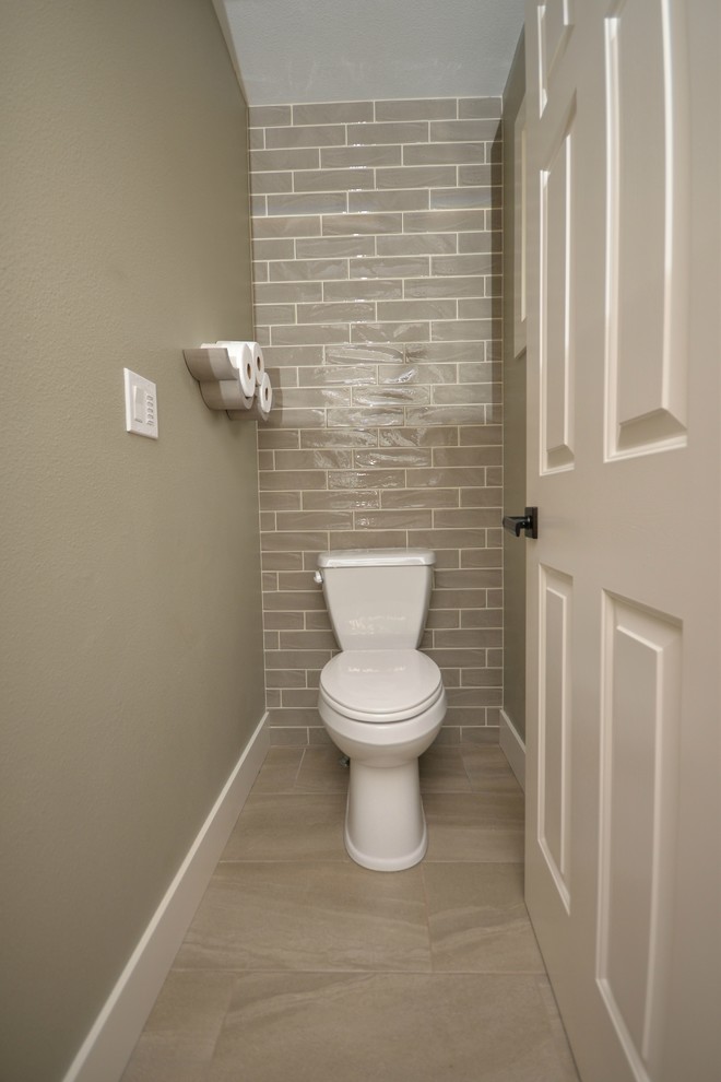 Inspiration pour un WC et toilettes traditionnel en bois brun de taille moyenne avec un placard à porte shaker, WC séparés, un carrelage marron, des carreaux de porcelaine, un mur gris, un sol en carrelage de porcelaine, un lavabo encastré, un plan de toilette en quartz et un sol beige.
