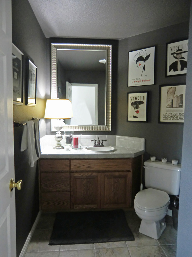 Modern inredning av ett mellanstort badrum med dusch, med ett nedsänkt handfat, släta luckor, skåp i mellenmörkt trä, kaklad bänkskiva, en dusch i en alkov, en toalettstol med hel cisternkåpa, grå kakel, keramikplattor, svarta väggar och klinkergolv i keramik