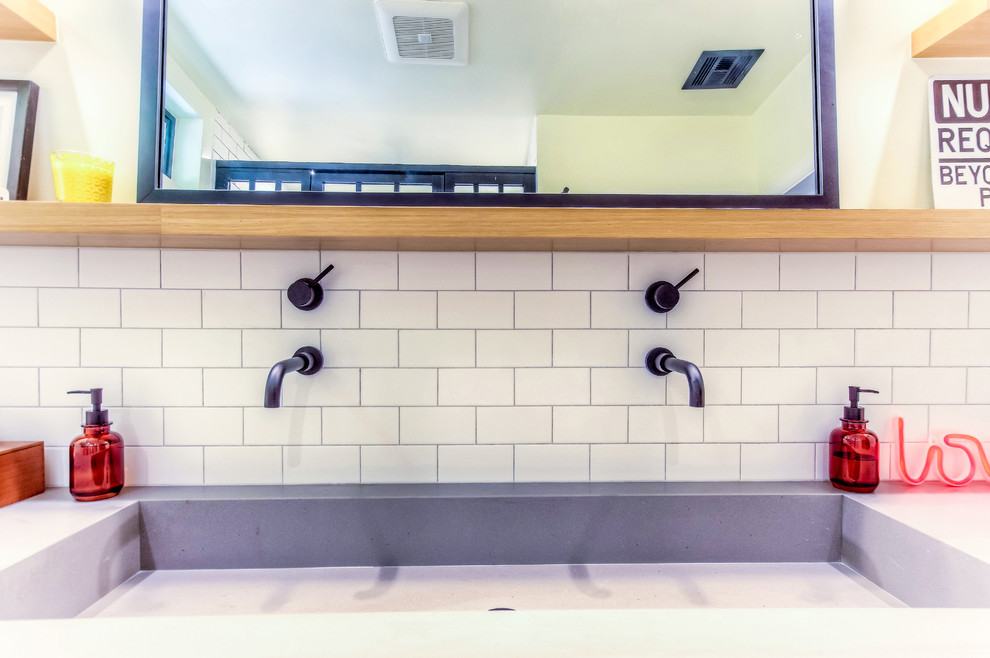 Foto på ett mellanstort vintage grå en-suite badrum, med släta luckor, skåp i ljust trä, en vägghängd toalettstol, vit kakel, tunnelbanekakel, grå väggar, cementgolv, bänkskiva i kvarts och flerfärgat golv