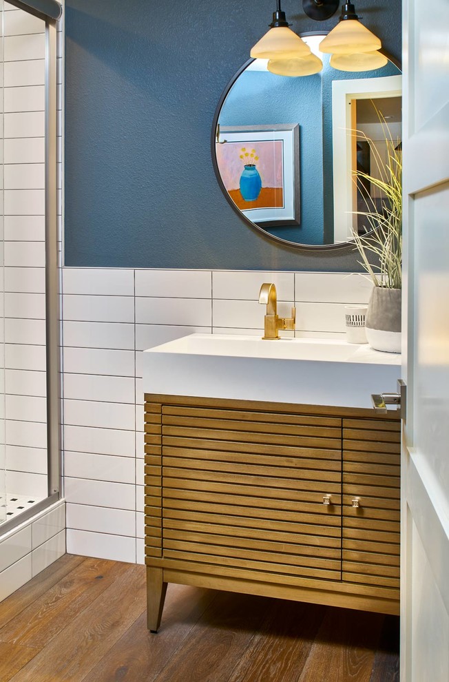 Источник вдохновения для домашнего уюта: ванная комната в современном стиле с фасадами островного типа, светлыми деревянными фасадами, угловым душем, черно-белой плиткой, керамической плиткой, синими стенами, паркетным полом среднего тона, душевой кабиной, раковиной с несколькими смесителями, столешницей из искусственного кварца, коричневым полом и душем с распашными дверями