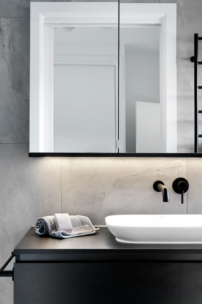 Idéer för svart badrum, med svarta skåp, vit kakel, cementkakel, grå väggar, cementgolv, ett fristående handfat, laminatbänkskiva och grått golv