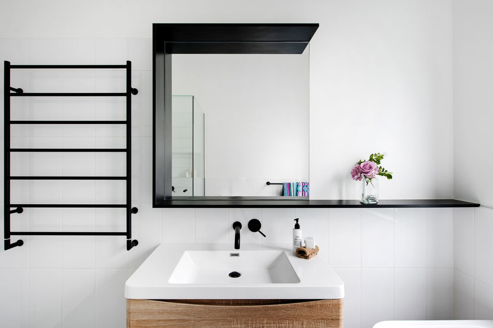 Diseño de cuarto de baño principal con puertas de armario de madera clara, baldosas y/o azulejos blancos, baldosas y/o azulejos de cerámica, lavabo integrado, encimera de granito y encimeras blancas