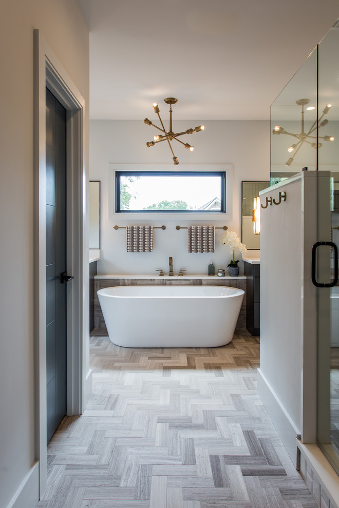 Expansive modern ensuite bathroom in Charlotte with flat-panel cabinets, brown cabinets, a freestanding bath, a double shower, a submerged sink, engineered stone worktops, brown floors, a hinged door, white walls and light hardwood flooring.