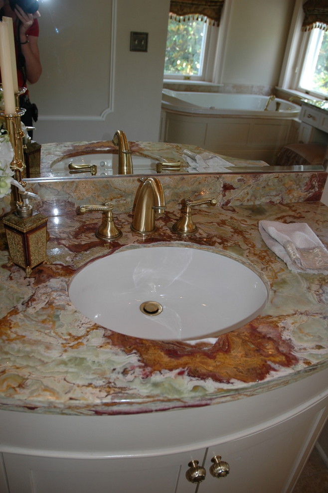 Cette image montre une très grande salle de bain principale traditionnelle avec un lavabo encastré, un placard en trompe-l'oeil, des portes de placard blanches, un plan de toilette en onyx, une baignoire posée, une douche ouverte, un carrelage rouge, du carrelage en marbre, un sol en marbre, un bidet, un mur vert, un sol beige, une cabine de douche à porte battante, un plan de toilette rouge, une niche, meuble simple vasque, meuble-lavabo sur pied, un plafond à caissons et boiseries.