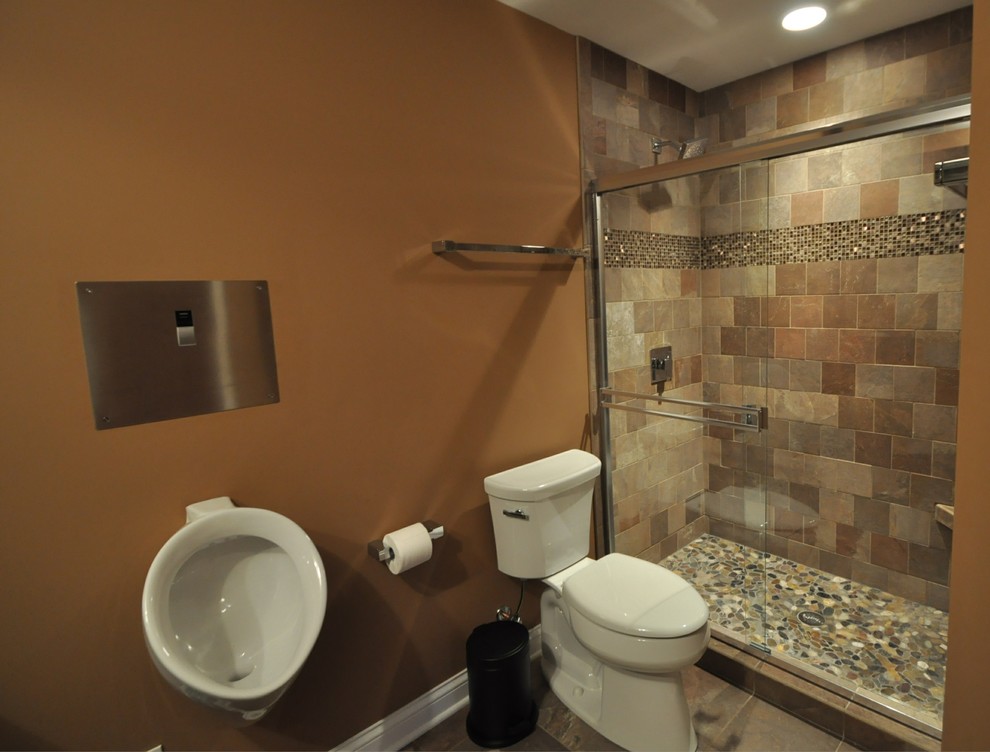 Modern inredning av ett stort badrum med dusch, med luckor med upphöjd panel, skåp i mellenmörkt trä, en dusch i en alkov, ett urinoar, beige kakel, brun kakel, stenkakel, beige väggar, skiffergolv, ett fristående handfat och granitbänkskiva