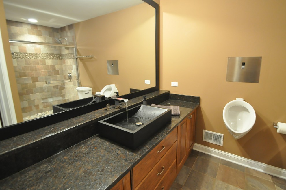 Aménagement d'une grande salle de bain moderne en bois brun avec un placard avec porte à panneau surélevé, un urinoir, un carrelage beige, un carrelage marron, un carrelage de pierre, un mur beige, un sol en ardoise, une vasque et un plan de toilette en granite.