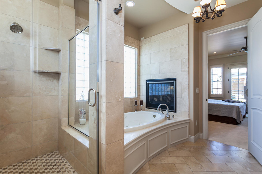 На фото: большая главная ванная комната в классическом стиле с бежевыми фасадами, ванной в нише, душем в нише, бежевой плиткой, плиткой из известняка, бежевыми стенами, полом из известняка, бежевым полом и душем с распашными дверями с