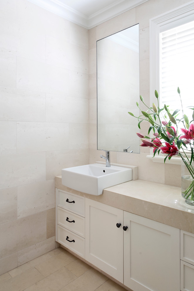 Inredning av ett klassiskt mellanstort en-suite badrum, med ett fristående handfat, luckor med infälld panel, vita skåp, marmorbänkskiva, beige kakel, stenkakel, beige väggar och marmorgolv