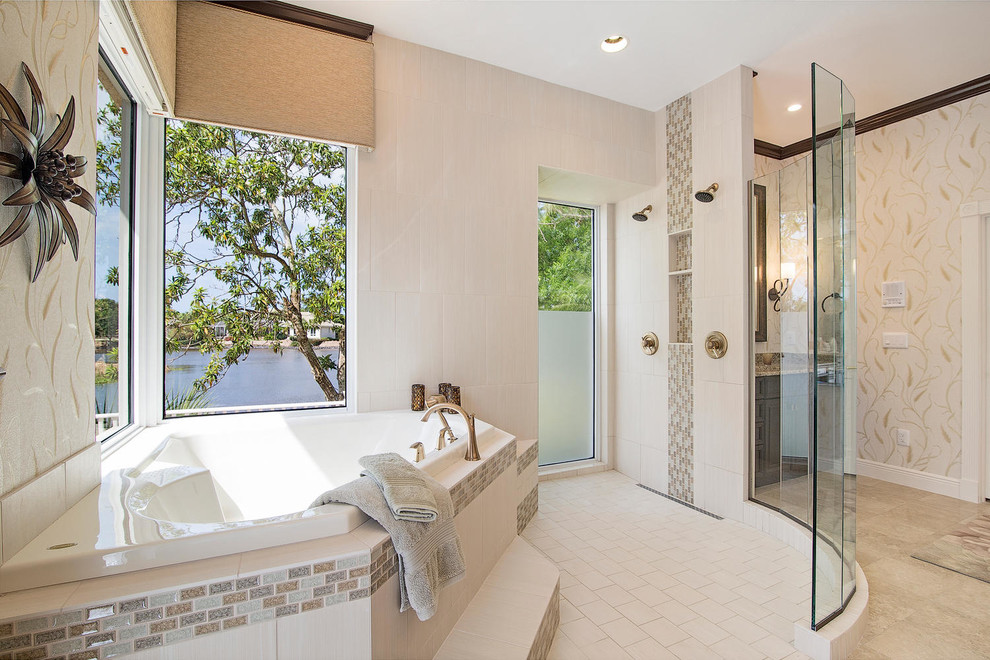 This is an example of a large traditional ensuite bathroom in Miami with recessed-panel cabinets, dark wood cabinets, a corner bath, a built-in shower, a one-piece toilet, beige tiles, porcelain tiles, a submerged sink, granite worktops, beige walls and travertine flooring.