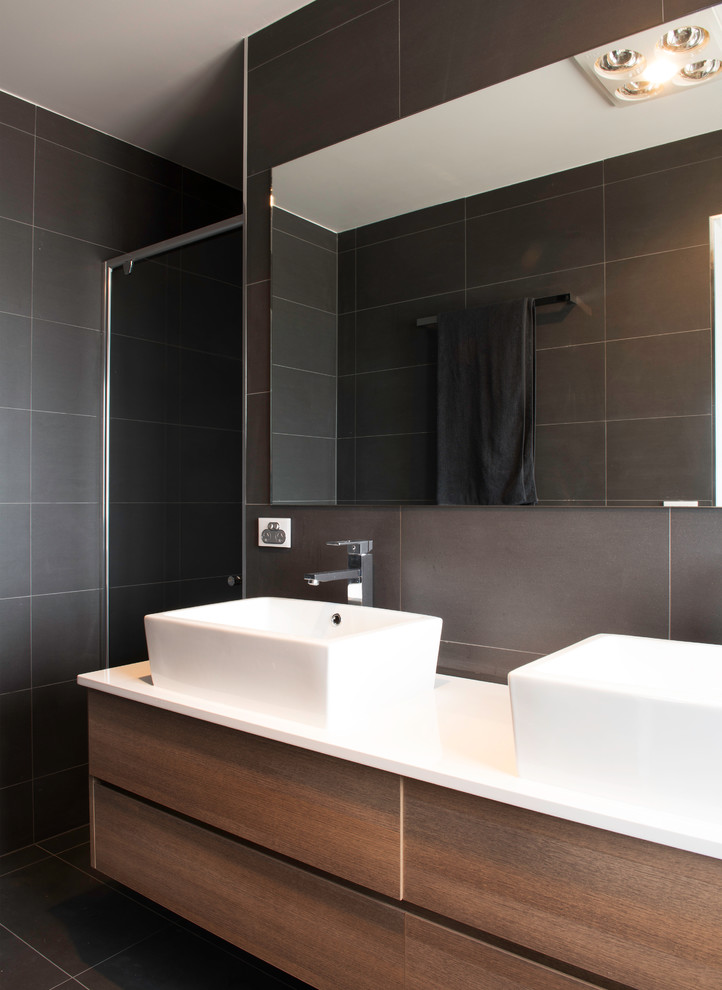 Photo of a medium sized modern shower room bathroom in Canberra - Queanbeyan with a vessel sink, flat-panel cabinets, medium wood cabinets, granite worktops, an alcove shower, grey tiles, ceramic tiles, grey walls and ceramic flooring.