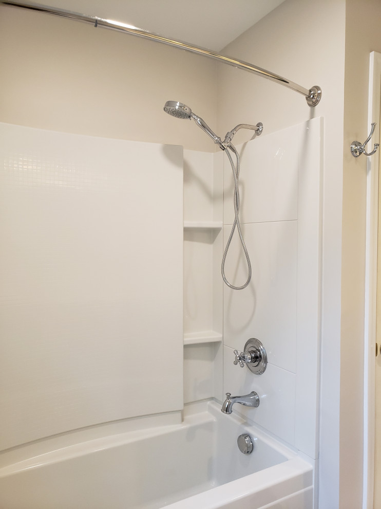 Mid-sized minimalist 3/4 gray floor bathroom photo in Other with recessed-panel cabinets, gray cabinets, a two-piece toilet, gray walls, an integrated sink, solid surface countertops and white countertops