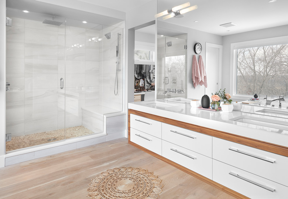 Идея дизайна: главная ванная комната в современном стиле с плоскими фасадами, белыми фасадами, душем в нише, белой плиткой, серыми стенами, светлым паркетным полом, врезной раковиной, бежевым полом и душем с распашными дверями